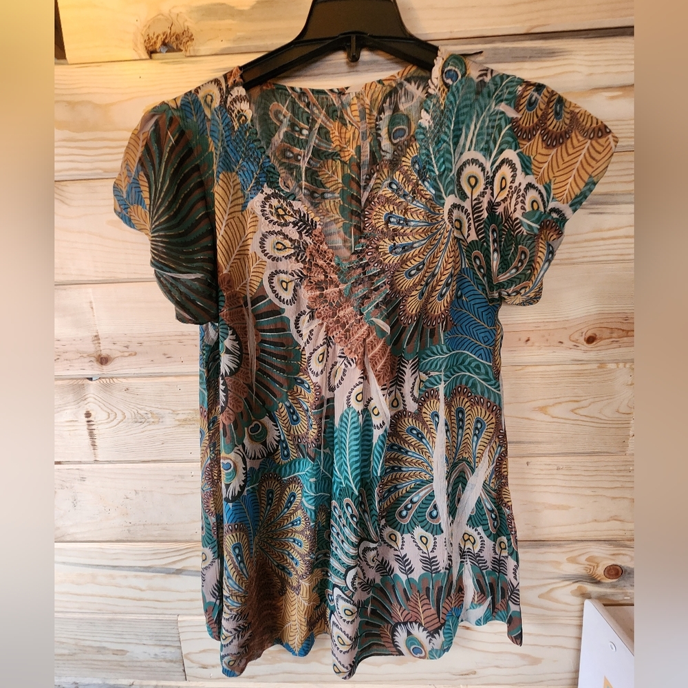 Pretty shirt! No brand but well made! About a S/M size. Shear and beautiful!